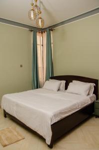 a bedroom with a large bed with white sheets at The Residency in Kampala