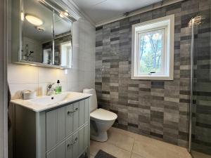 Un baño con lavabo, inodoro y ventana. en Charming and spacious villa near Lidköping, en Hede