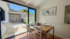a dining room with a table and chairs on a patio at Dans le centre village de Sainte Marie de Ré, charmante location entièrement rénovée in Sainte-Marie-de-Ré