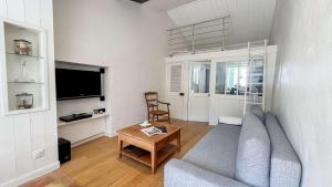 a living room with a couch and a table at Dans le centre village de Sainte Marie de Ré, charmante location entièrement rénovée in Sainte-Marie-de-Ré
