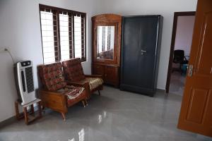 a living room with a chair and a tv at HOLYDAy HIDEOUT in Vandanmedu