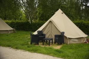 2 Stühle und ein Zelt im Gras in der Unterkunft Belle Tent - Camping Belle-Vue in Berdorf