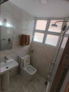 ein Badezimmer mit Waschbecken und Toilette und einem Fenster in der Unterkunft Hotel Ambrosia, Charikot, dolakha in Charikot + 33 Fotos