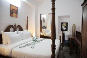 Un dormitorio con una cama grande con espejo. en Prem Niwas a Heritage Hotel & Homestay, en Udaipur