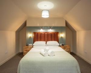 Un dormitorio con una cama grande con toallas. en Taynuilt Inn Apartments, en Taynuilt