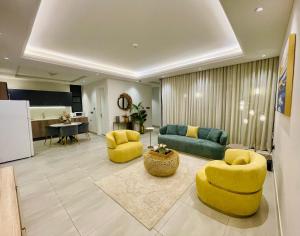 a living room with yellow chairs and a couch at Spacious new 2 bedroom Apt-in amazing location B9 in Riyadh