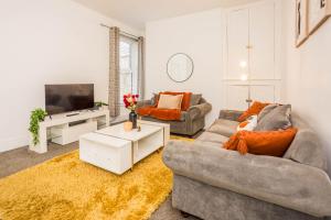 a living room with two couches and a tv at St Pauls Terrace in Ryhope