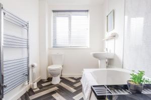 a bathroom with a tub and a toilet and a sink at St Pauls Terrace in Ryhope +50 photos
