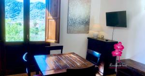 a living room with a wooden table and a desk at Residenza Locci - Rooms & Apartments in Teulada