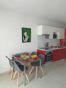 a kitchen with red cabinets and a table and chairs at Bungalow Médano in El Médano