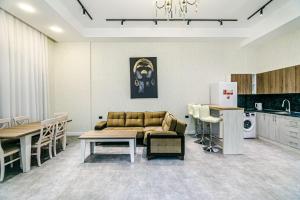 バクーにあるAmazing VIP Apartment MARIOTTのソファとテーブルとキッチンのあるリビングルーム