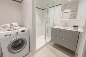 Un baño blanco con lavadora y ducha. en Le Nova du Laudon - Centre Saint-Jorioz et proche plage, en Saint-Jorioz 14 fotos más