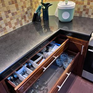 a kitchen counter with a drawer filled with wine glasses at Ndalem Srigading Villa Solo Entire Villa in Bonorejo
