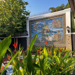 a mural on the side of a building with plants at Ndalem Srigading Villa Solo Entire Villa in Bonorejo +47 photos