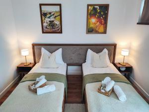 a hotel room with two beds with towels on them at Pensiune și Restaurant Silvania in Poiana Măgura