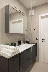 un baño con lavabo y espejo en Frant Living - Graz Apartments, en Graz 87 fotos más