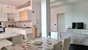 una cucina e una sala da pranzo con tavolo e sedie di La Casa di Anastasya a Gassino Torinese