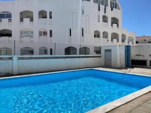 a large blue swimming pool in front of a building at Maryland Terrace by RPG Properties in Albufeira
