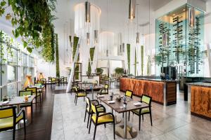 a restaurant with tables and chairs and a bar at Sheraton Milan Malpensa Airport Hotel & Conference Centre in Ferno +33 photos