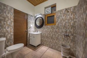 a bathroom with a toilet and a mirror on the wall at 2 Bhk l Kasauli l Kasauli Home l Serviced Apartments in Kasauli +49 photos