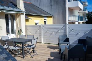 eine Terrasse mit Tisch und Stühlen und einem Zaun in der Unterkunft T3 centre ville 70 m2 avec terrasse in La Baule