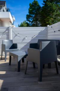 Eine Gruppe von Bänken steht neben einem weißen Zaun. in der Unterkunft T3 centre ville 70 m2 avec terrasse in La Baule