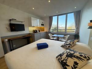 a large white bed in a room with a kitchen at Residence Issy in Issy-les-Moulineaux