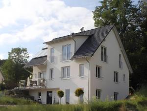 a white house with a black roof at Ferienwohnung Im Laubgarten in Öhningen