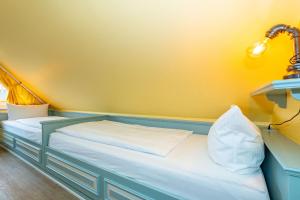a bed in a room with a yellow wall at Priel-Hüs in List