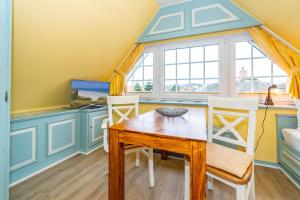 a dining room with a table and chairs and a window at Priel-Hüs in List