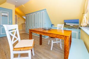 a dining room with a wooden table and chairs at Priel-Hüs in List +77 photos