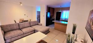 ein Wohnzimmer mit Couch und Küche in der Unterkunft 3 Bedroom Apartment in Roodepoort