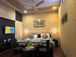 a room with a bed and a table and chairs at Shaleen Elegance Homestay Near Nakki Lake in Mount Ābu
