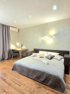 a bedroom with a large bed and a desk at The pearl of the city with a great view of the whole Kyiv in Kyiv