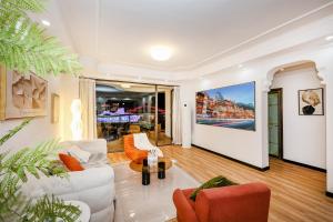 a living room with white furniture and a large painting on the wall at Baihong Riverview aparment-ChaoTianMen in Chongqing