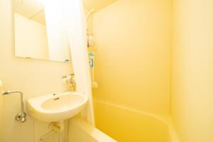 een gele badkamer met een wastafel en een bad bij Maison de Grue 601 in Sapporo +31 foto's
