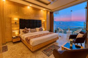 a bedroom with a large bed and a balcony at Hotel Lily Woods, Near JW Marriott Mussoorie - A Beautiful Lavish & Luxury Hotel with Mountain View Managed By Lily in Mussoorie