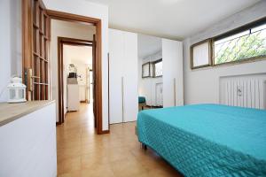 a bedroom with a blue bed and a window at WIRO L'Ulivo -20 min from Malpensa and Rho Fiera in Inveruno