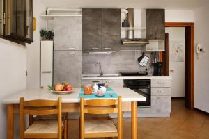 a kitchen with a table with a bowl of fruit on it at WIRO L'Ulivo -20 min from Malpensa and Rho Fiera in Inveruno