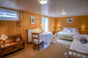 une chambre avec un lit, une table et des chaises dans l'établissement Nuits et Jardin, à Nuits-Saint-Georges