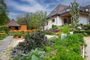 un jardin devant une maison avec des fleurs dans l'établissement Nuits et Jardin, à Nuits-Saint-Georges