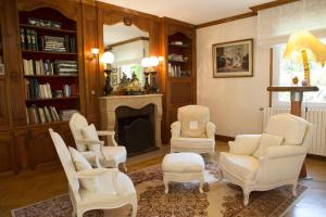 - un salon avec des chaises blanches et une cheminée dans l'établissement Nuits et Jardin, à Nuits-Saint-Georges