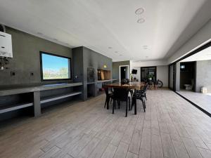 Una sala de estar con una mesa y sillas y una ventana. en Funes temporario, en Funes