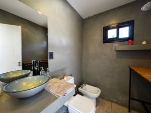 Un baño con dos lavabos y un inodoro. en Funes temporario, en Funes