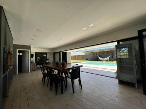 comedor con mesa, sillas y piscina en Funes temporario, en Funes