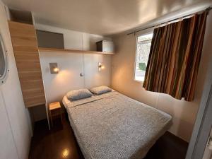 a small bedroom with a bed and a window at Camping Neptuno in Pals +32 photos