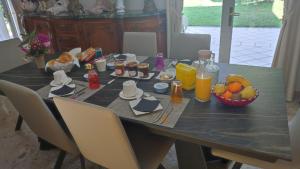 ein Tisch mit einem Frühstück aus Saft und Obst darauf in der Unterkunft Les Hortensias Du Monastère in Saint-Aubin-de-Médoc
