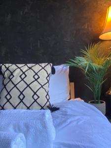 a bed with a blue comforter and two pillows at Hunters Cabin - Rustic farm stay in Great Chart