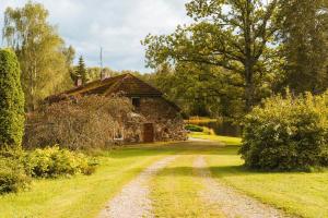 a dirt road in front of a stone house at Jeiskas dzirnavas in Launkalne