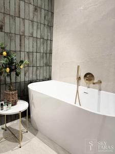 y baño con bañera blanca y mesa. en SkyTaras - Apartament przy Tężni, en Busko-Zdrój 22 fotos más